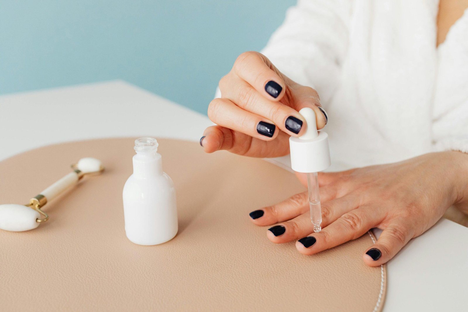 Hands applying oil to dry cuticles for nail care