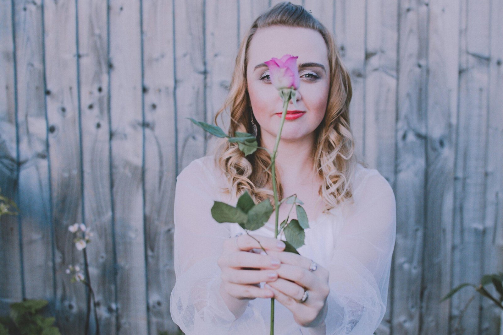 A woman applying warm organic oil to her hair using fingertips