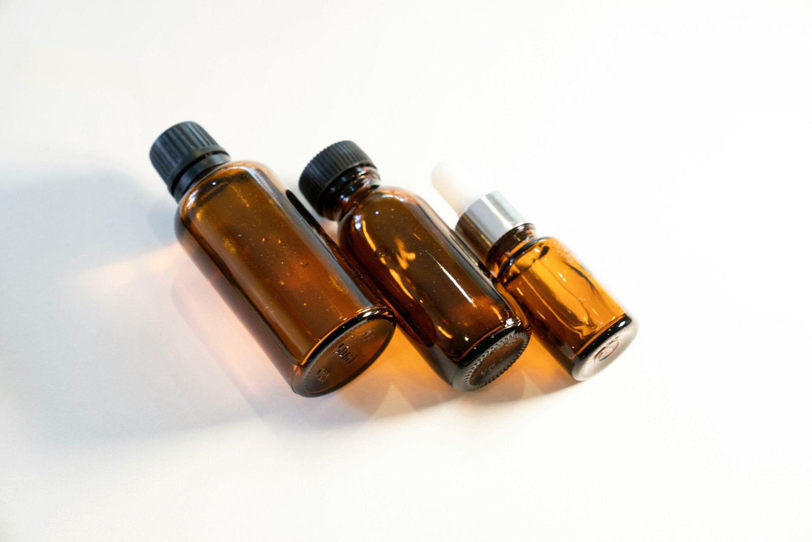 A collection of essential plant oils bottles on a wooden table