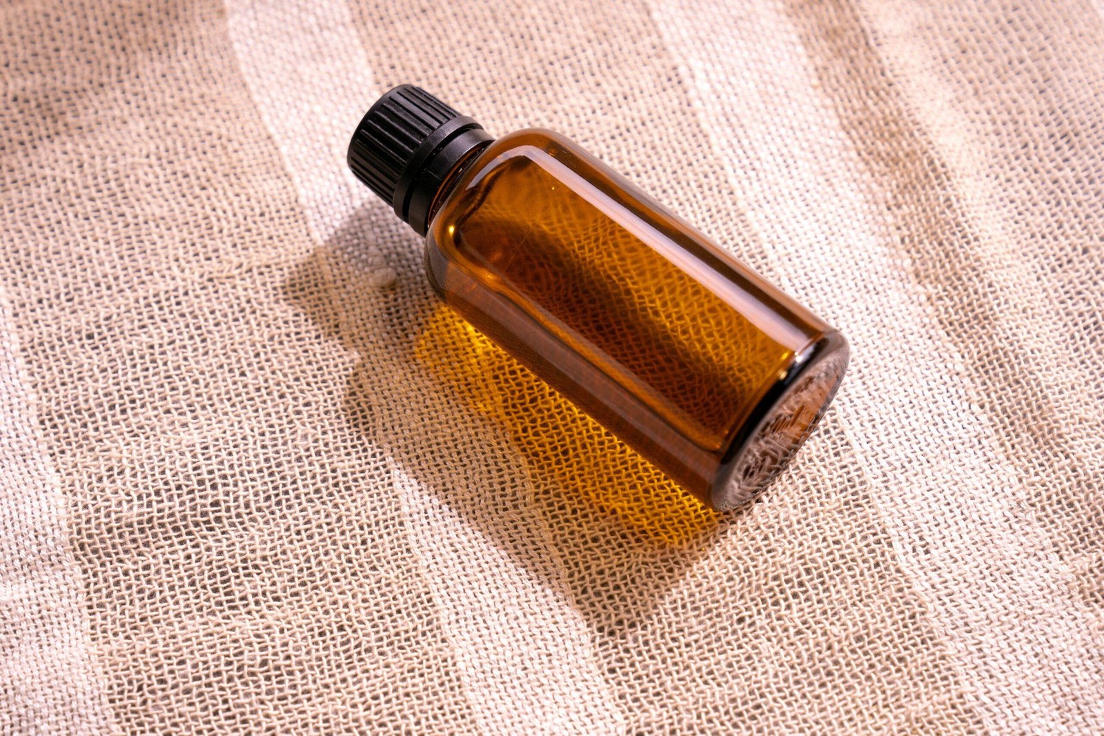 Dropper dispensing organic oil onto fingers