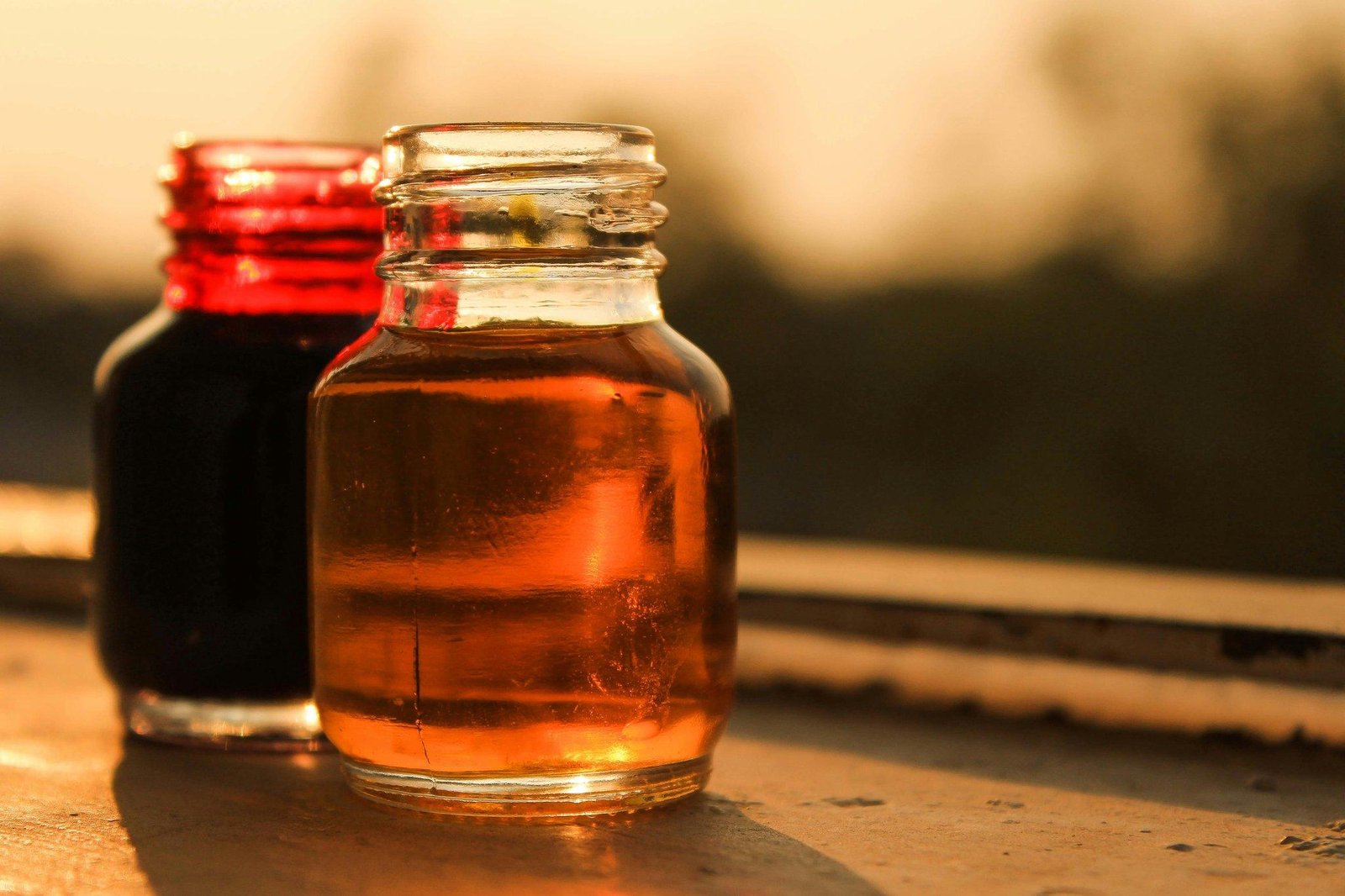 A person checking their phone while holding a product labeled 'Organic Rosehip Oil'
