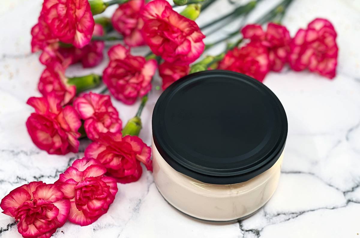 Woman applying coconut oil blend onto her skin for hydration